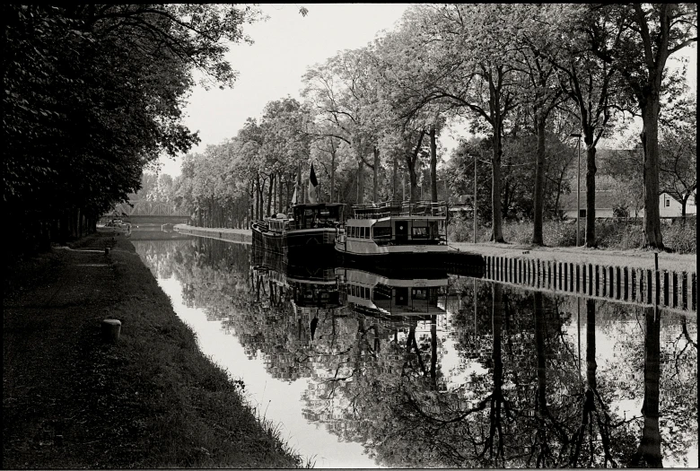 a river that has boats in it and trees around it