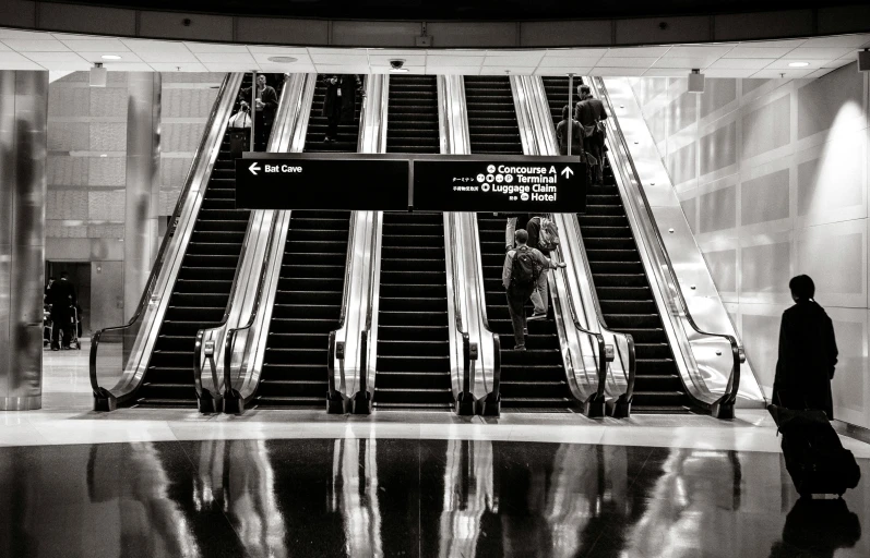 an escalator and people standing on the sidewalk