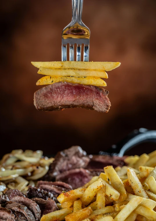 a fork with food on it and fries below