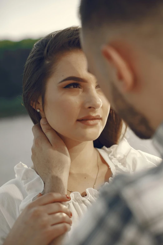 a man is touching the neck of a woman