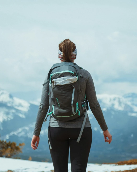 a person wearing a backpack standing on a trail