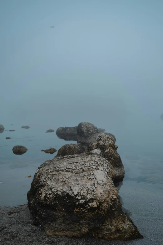a rock sits on the shore of a lake