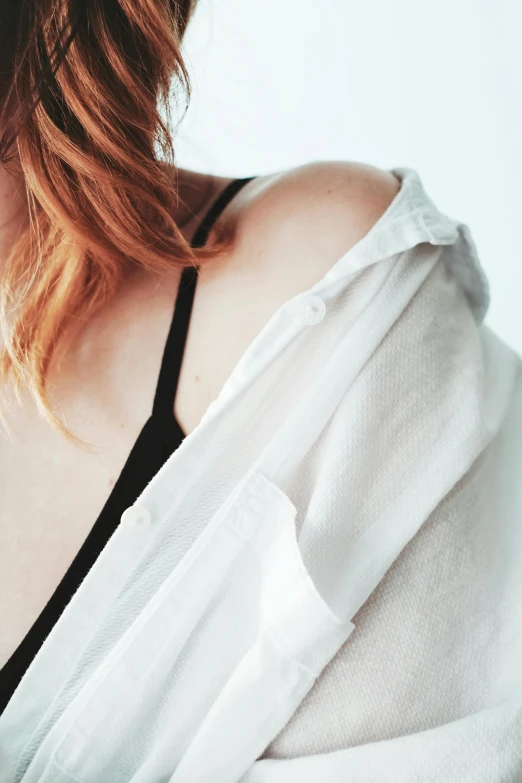 a close up of a woman's  with a white blouse on