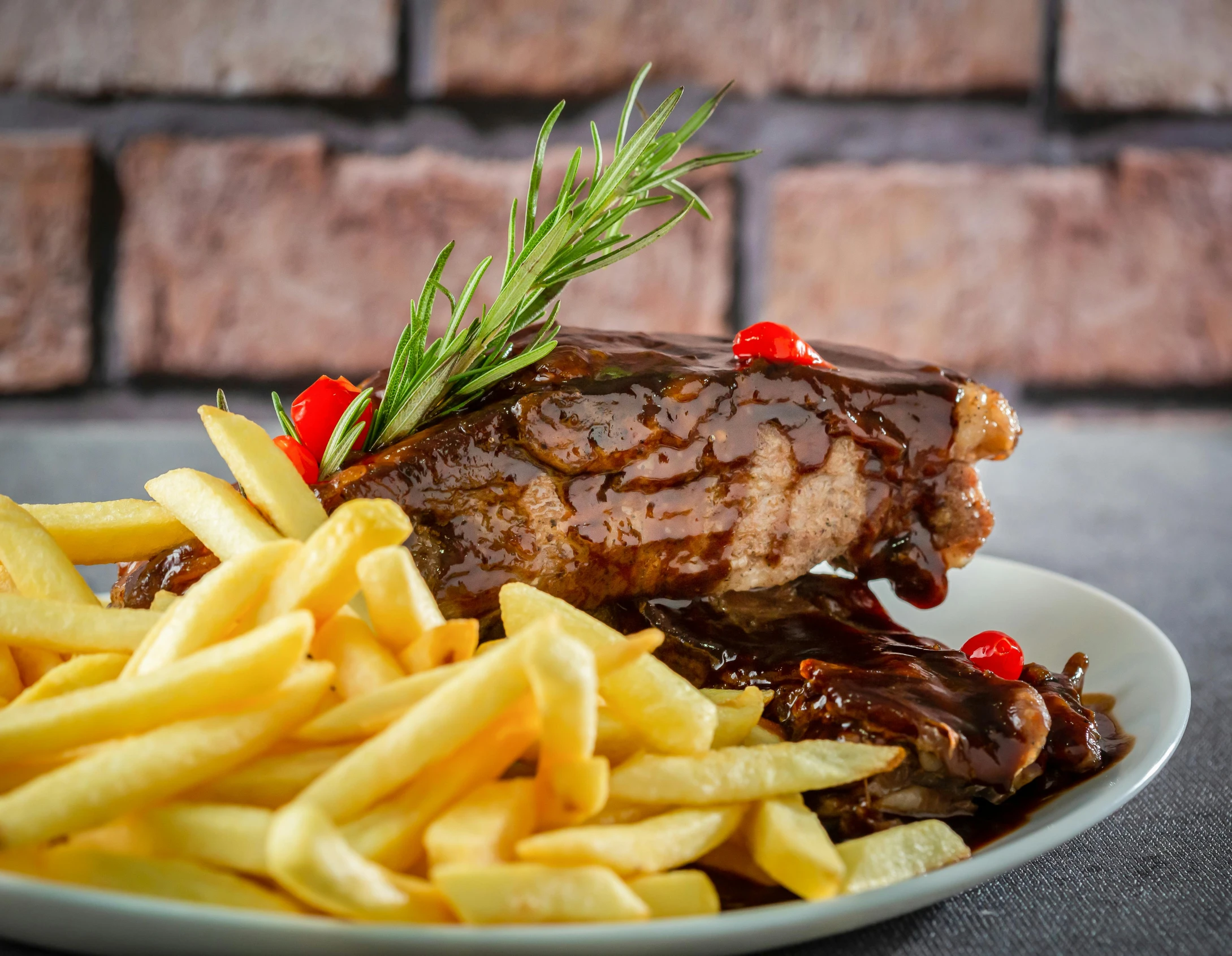 a close up of meat and french fries on a plate