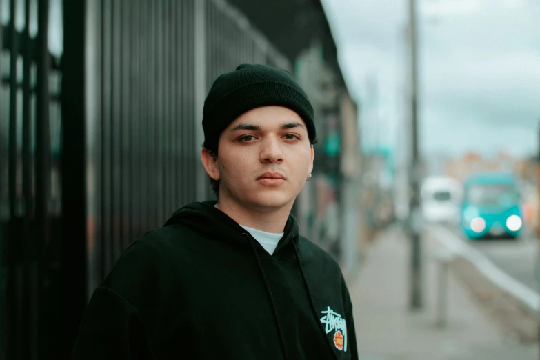 a guy poses for a picture in front of an alley