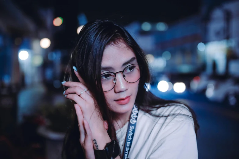 woman with glasses on phone in city street