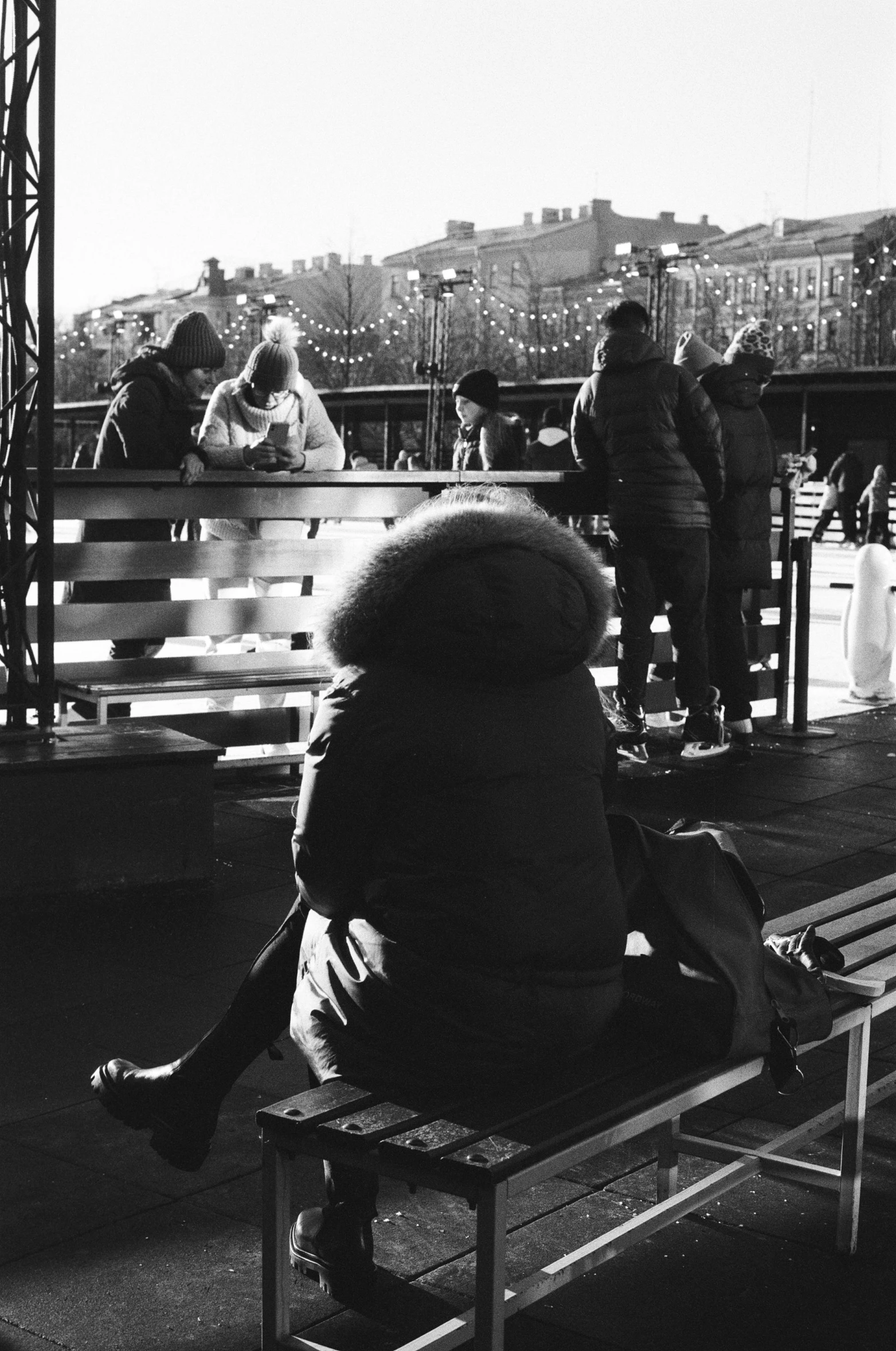 a person sitting on a bench with a lot of people on it