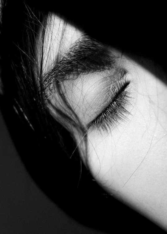 the black and white image of a woman's eye and hair