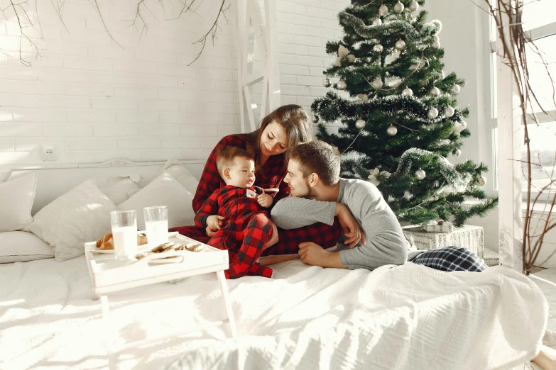 a family sits on the bed during christmas time