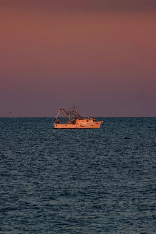 two boats sailing in the ocean during sunset