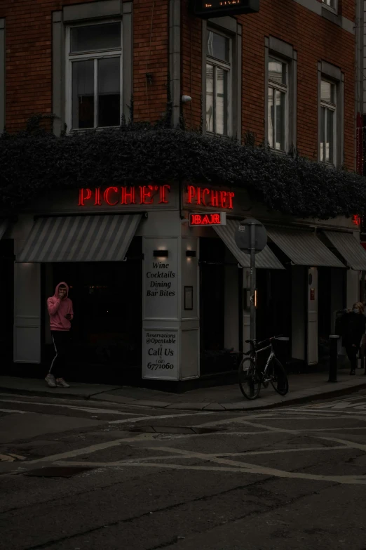 people standing outside of a restaurant next to the street