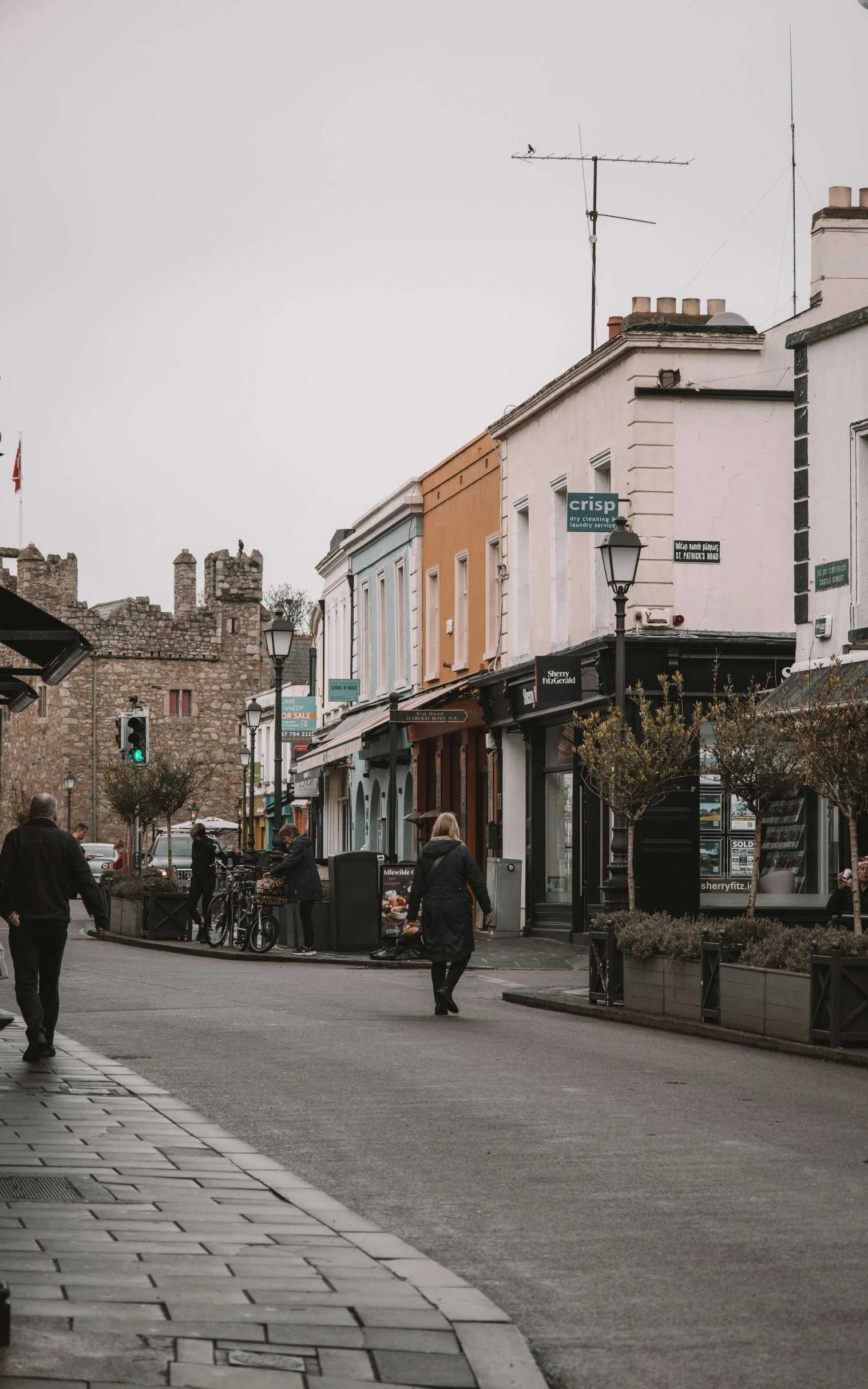 a few people are walking in a very small town