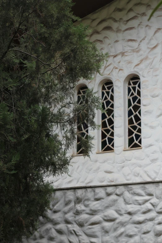 a small white building with a tree outside of it