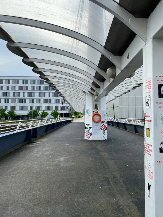 some people walking down a bridge with some buildings in the background