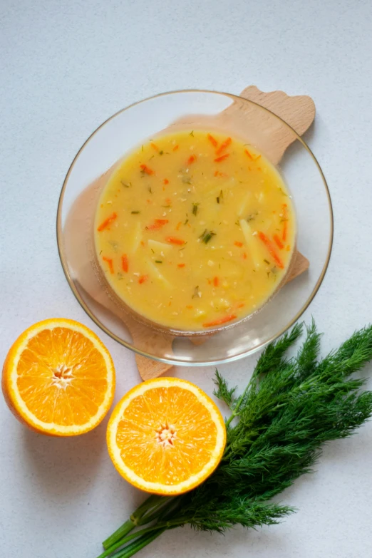 a glass bowl and knife on a table next to orange halves