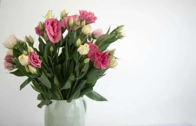 a vase with pink and white flowers inside