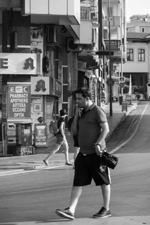 a man and girl crossing the street while talking on their phones