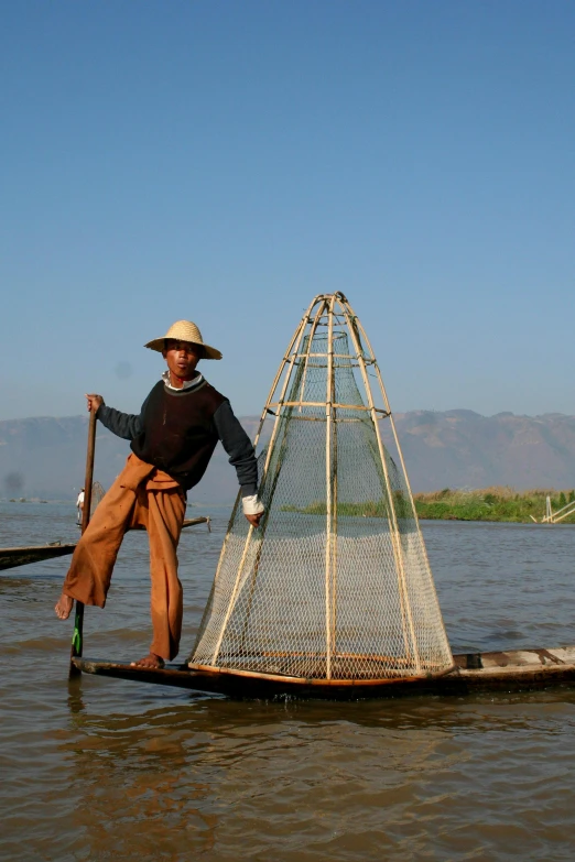 the man is rowing in his boat to catch fish