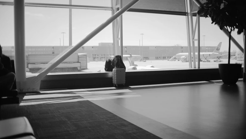 the airplane is parked on the runway by the large window