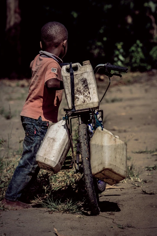 a  picking up his bicycle from the mud