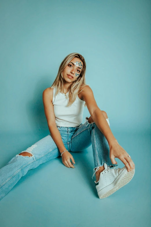 a young blond woman posing with her feet crossed