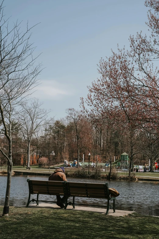 an animal sleeping on top of a wooden bench