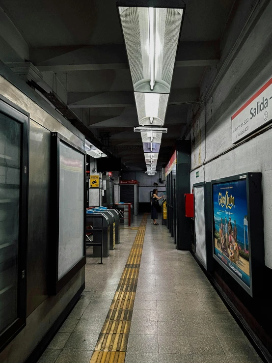 a empty metro train station with people entering and leaving