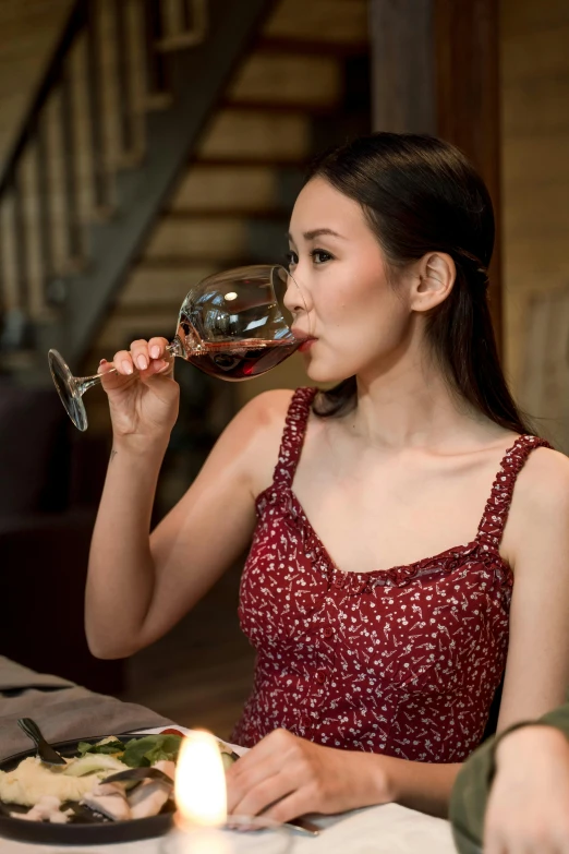 a woman sipping red wine from a glass