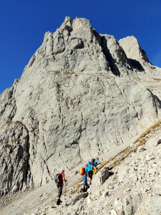 people are climbing the mountain on a trail