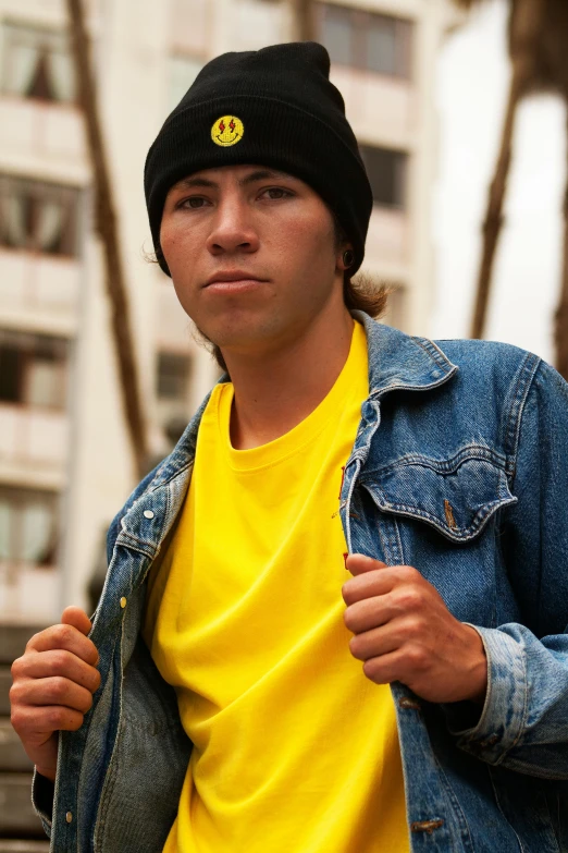 a young man in yellow shirt and hat in the city