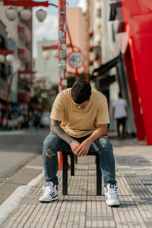 a young man sitting in front of a clock tower