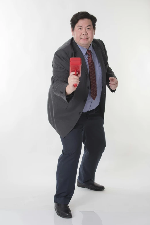 a man dressed in suit and tie is holding a red phone