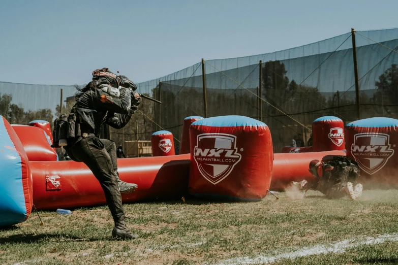 man using large, inflatable obstacles to play on soccer field