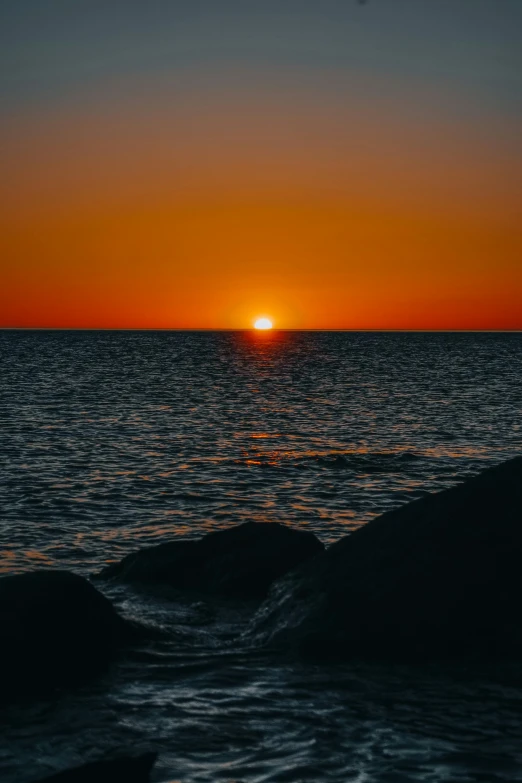 a sunset with the sun setting over the ocean