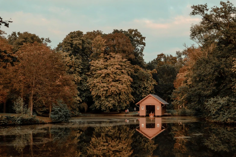 the small red house is located on top of a body of water