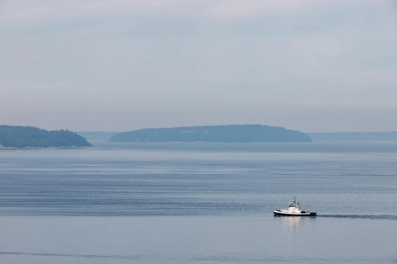 a boat traveling down a calm ocean during the day