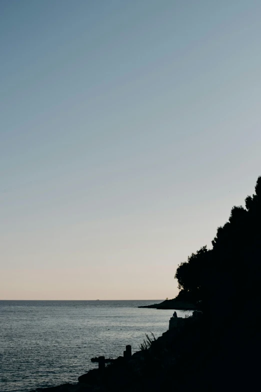 a bench sitting on top of a rocky hill by the ocean