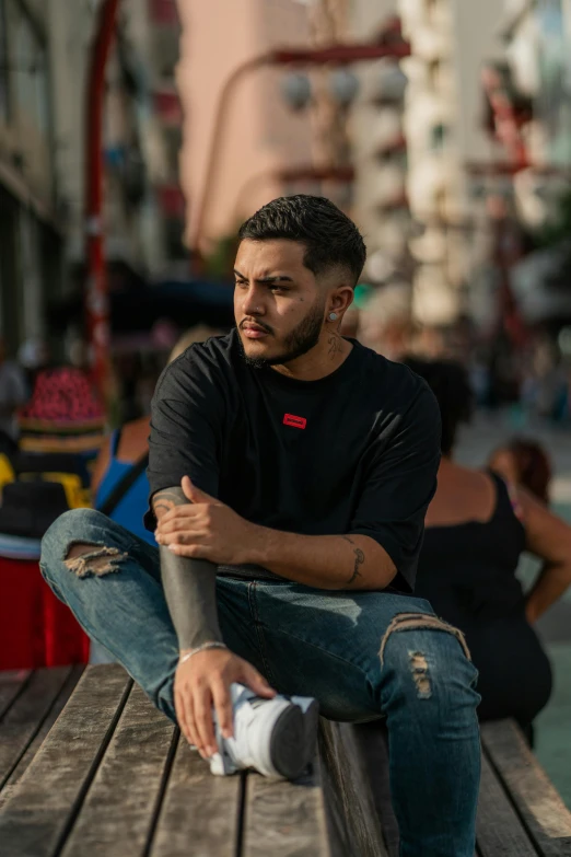 a man is sitting on a bench with his arms crossed