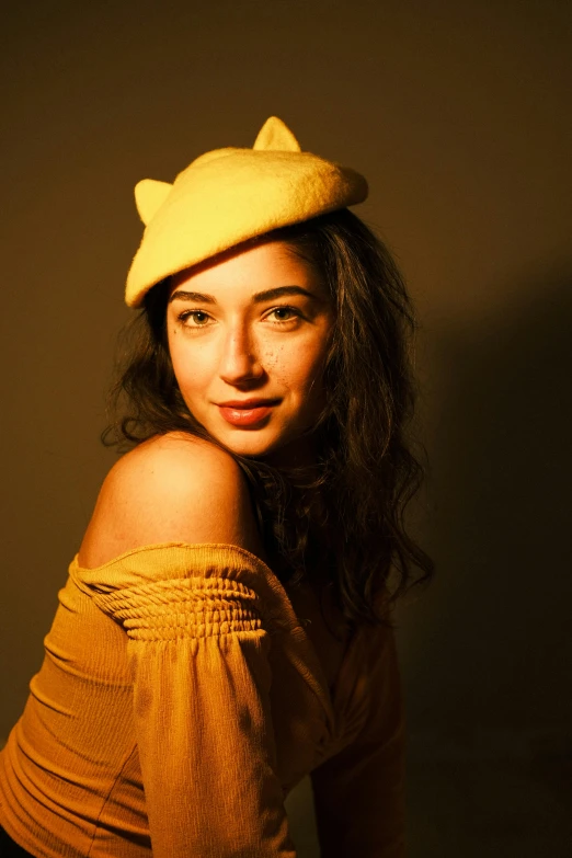 a woman in a yellow top with a cat hat