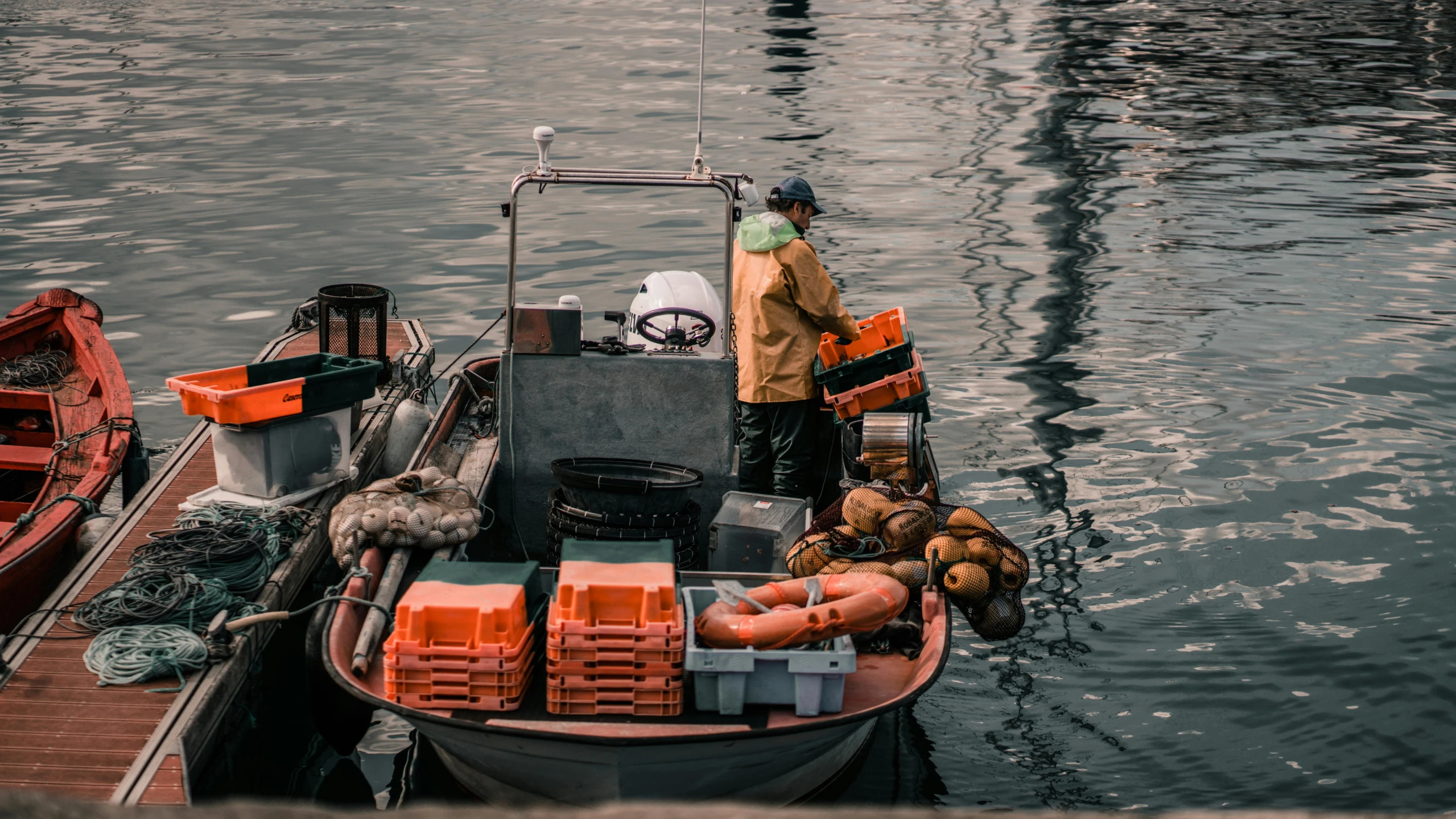 a man in an orange jacket on a boat