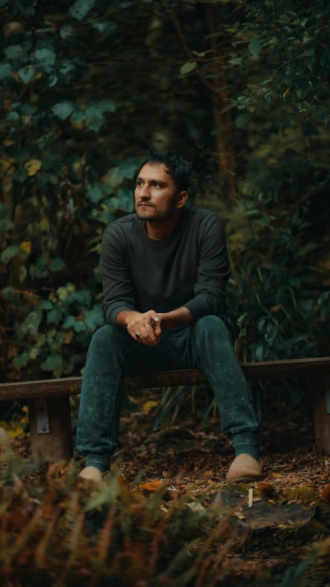 a young man sitting on top of a bench