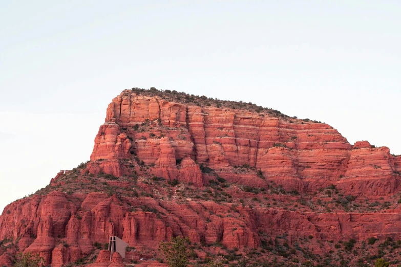 large red mountain with a cross in the foreground