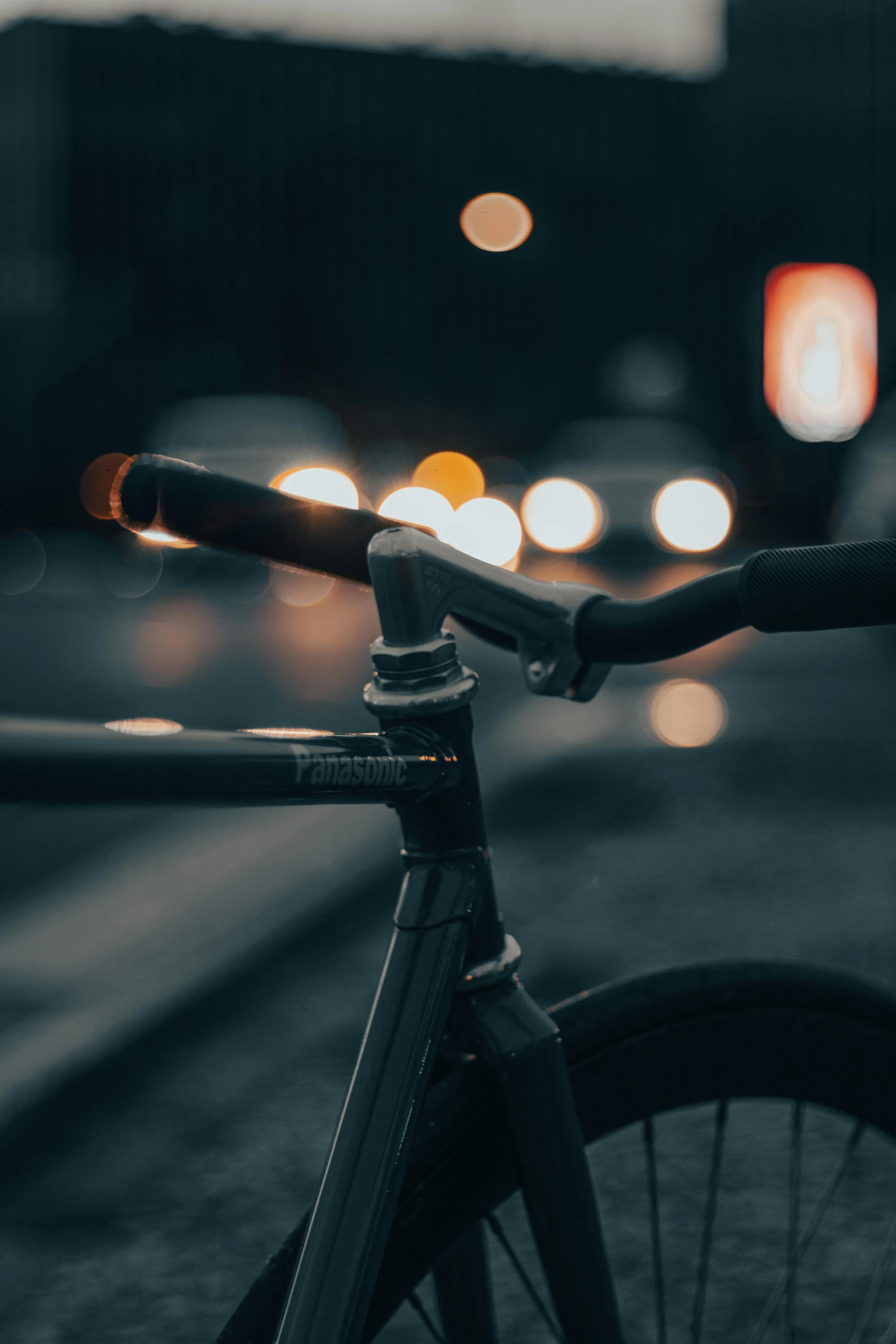 a bike is lit up in the dark with street lights in the background