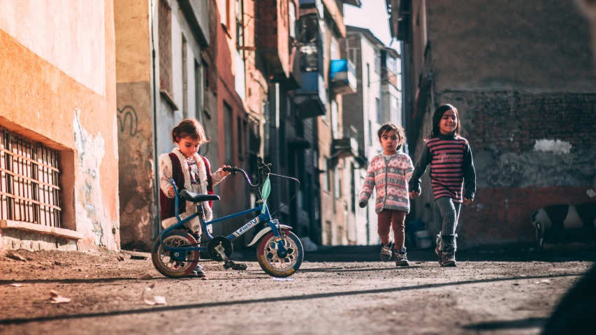 a group of children walking down an old street