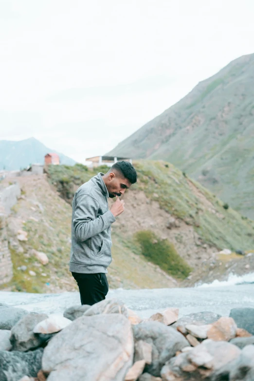 man looking down as he walks by rocks and rocks