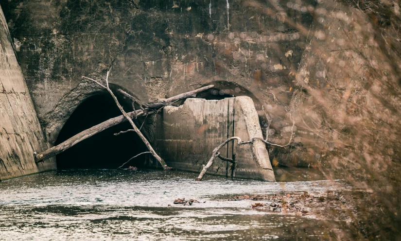 an open tunnel sitting above a small body of water