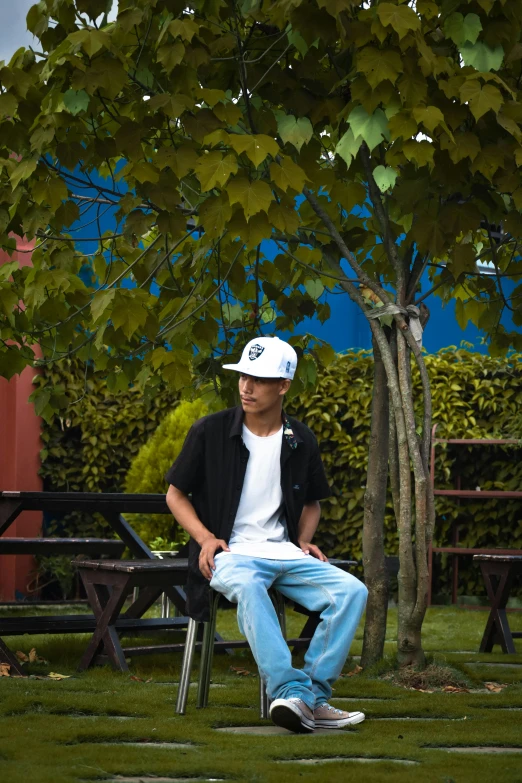 a man in white hat sitting on a bench