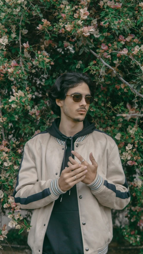 the man is standing in front of flowers and trees