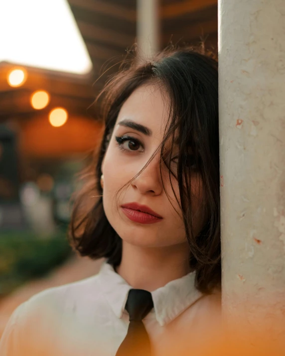 a young lady posing with a white shirt and black tie