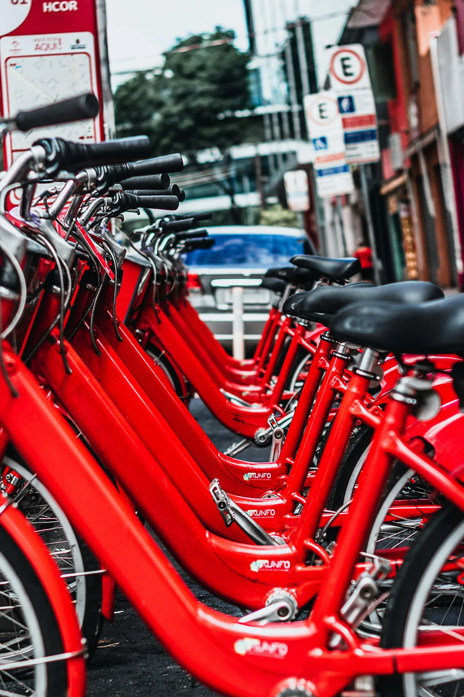 many bicycles parked next to each other in front of a street sign